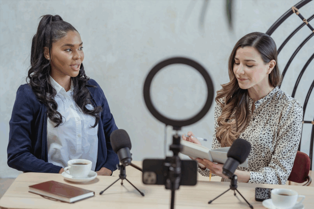 Work-with-Reporters-Cover Two girls in front of microphones and camera